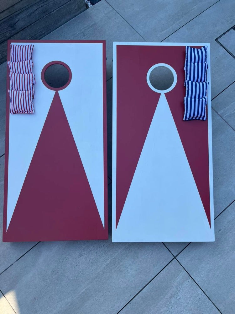 Front view of large red and white hand-painted wooden cornhole boards
