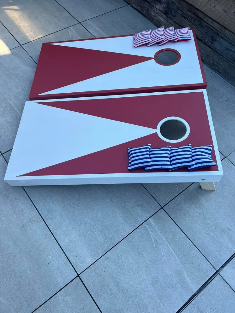 Large red and white wooden cornhole boards with matching bean bags